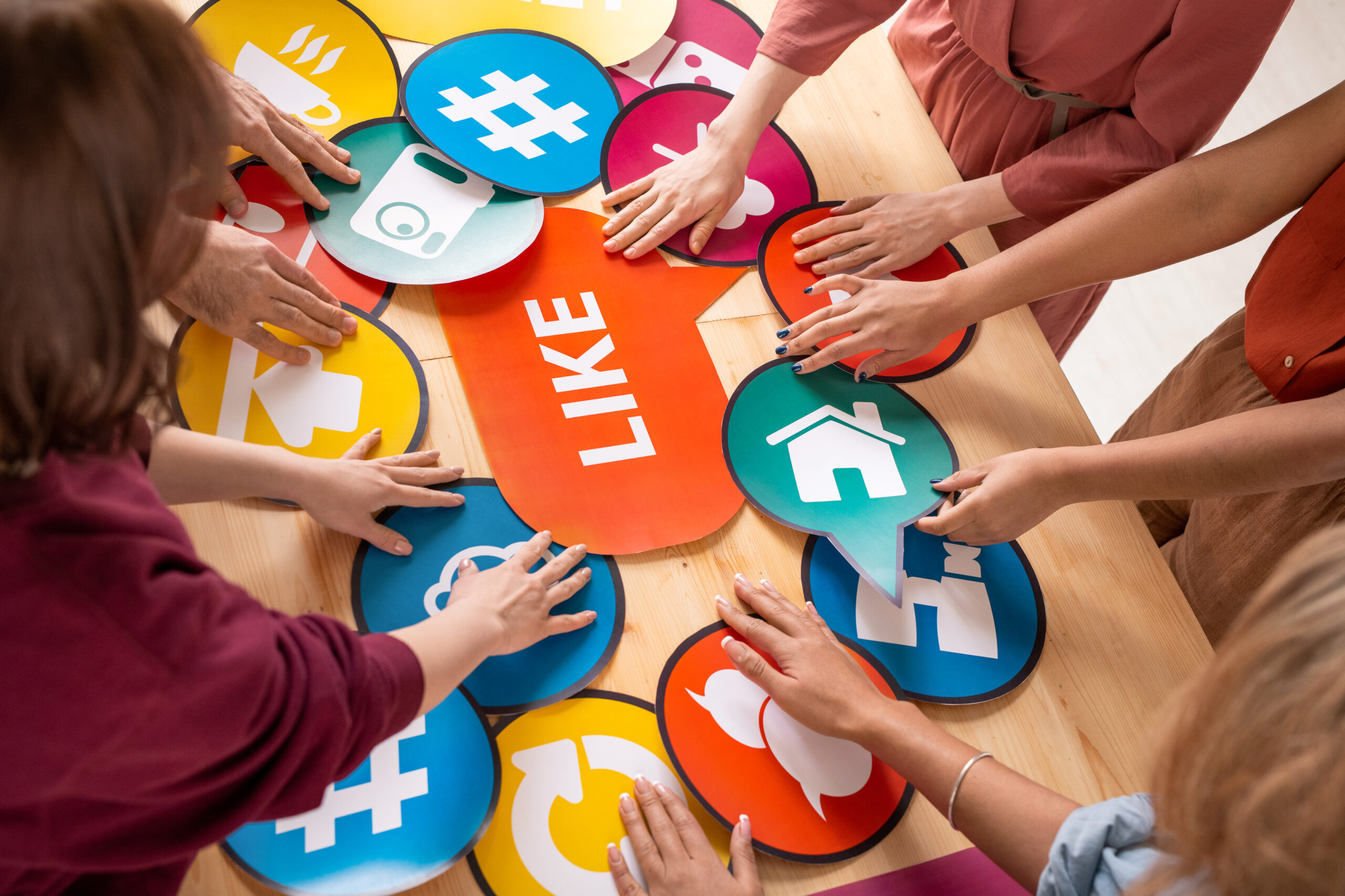 Hands of several friendly millennials choosing paper speech bubbles with icons