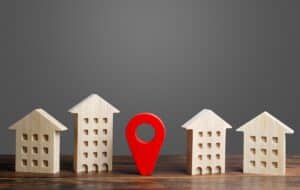 A red location indicator stands between residential buildings. Location and surroundings of the building. Moving Search best for options. Nice neighborhood. Infrastructure and utilities.