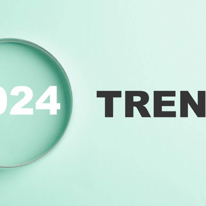 The image features magnifier glasses with the text New Year 2024 Trends, emphasizing the main trend of change. It represents the evaluation methods, popular topics, and new trends in business.