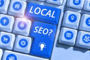Close-up of a computer keyboard with blue keys labeled "LOCAL" and "SEO?", surrounded by icons for home, settings, and more—highlighting how Website Design Mistakes San Antonio can impact local search results.