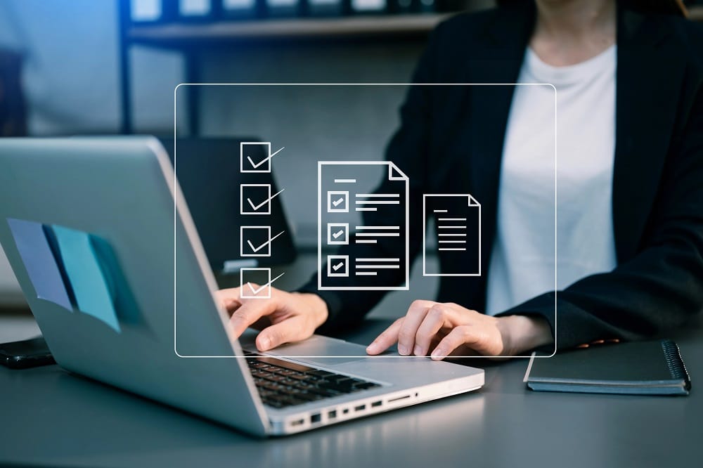 Person typing on a laptop with a checklist graphic over the screen