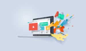 A laptop displays web design elements on its screen, with colorful 3D shapes and icons emerging from the display, symbolizing creativity and digital content creation for Web Design in Northeast San Antonio.