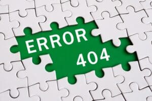 A jigsaw puzzle with missing pieces reveals the text "ERROR 404" on a green background beneath the puzzle.
