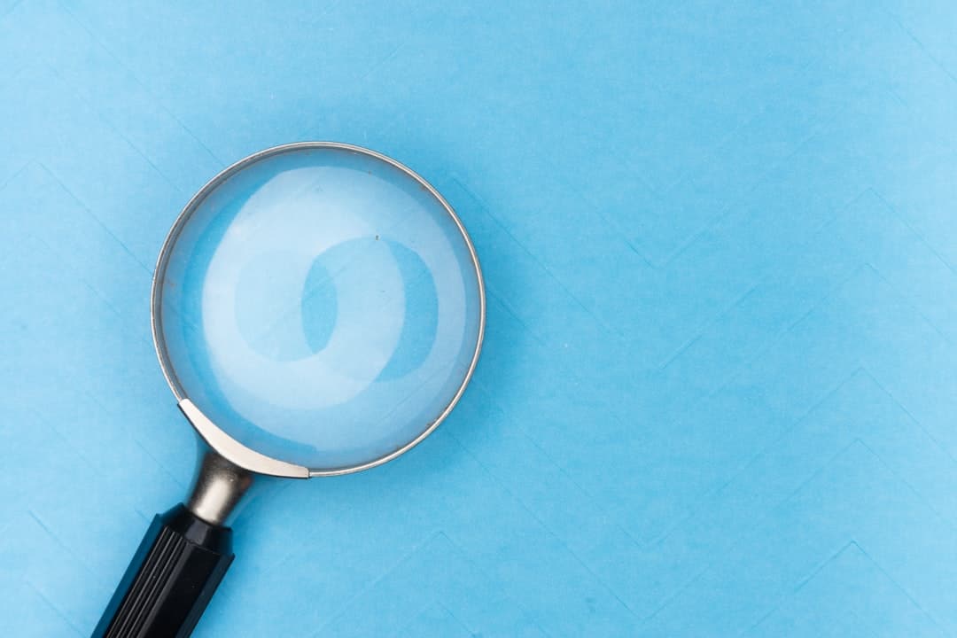 Magnifying glass on a blue background, representing search visibility