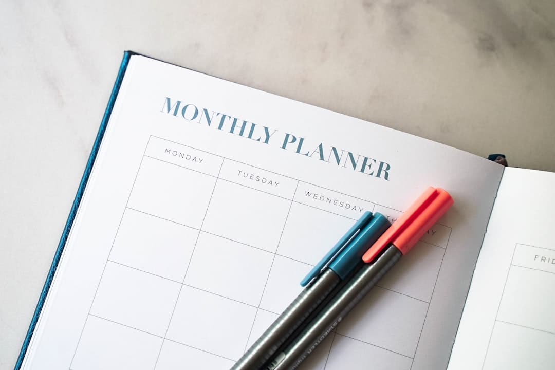 Open monthly planner with pens, representing the twelve month horizon of an SEO retainer