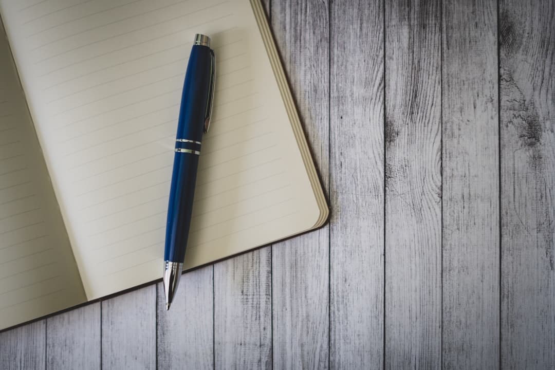 Blue pen resting on an open notebook, representing on-page SEO work