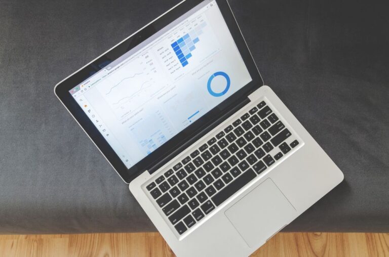 Overhead view of an open laptop displaying a website analytics dashboard with traffic graphs and a donut chart.
