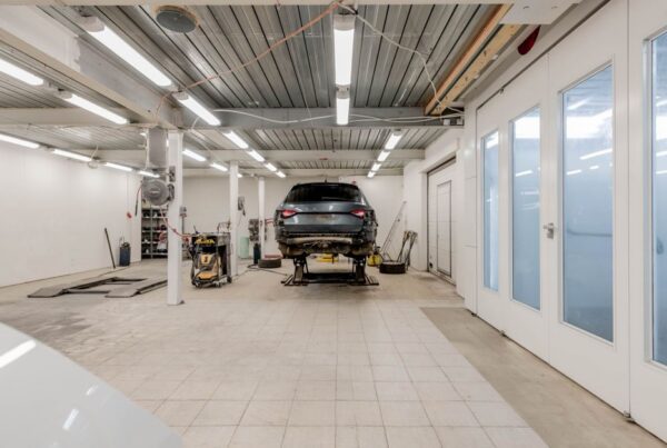 Clean auto repair shop service bay with a vehicle raised on a hydraulic lift