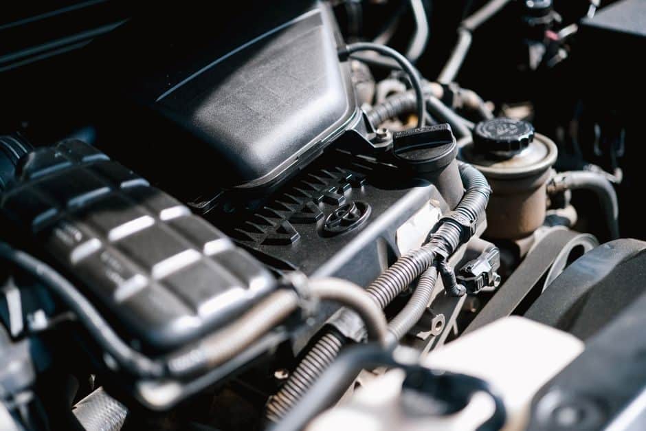 Close-up of a car engine bay showing hoses, wiring and engine components