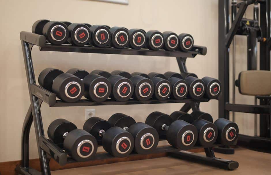 Rack of dumbbells arranged by weight in a gym strength training area