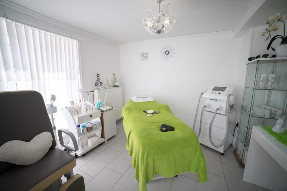 Med spa treatment room with a covered treatment bed and skincare equipment