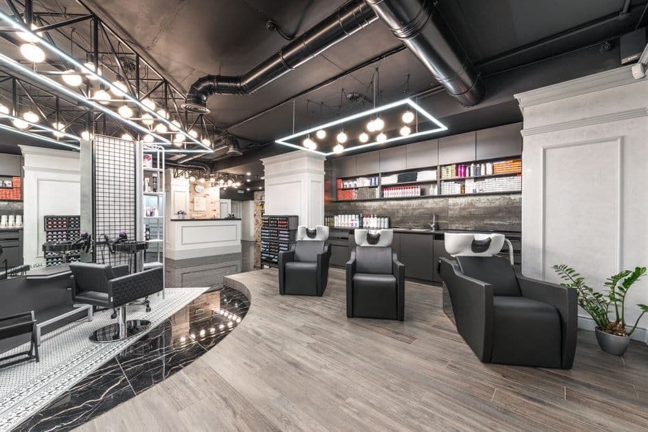 Salon backwash area with shampoo chairs and product shelving along the wall