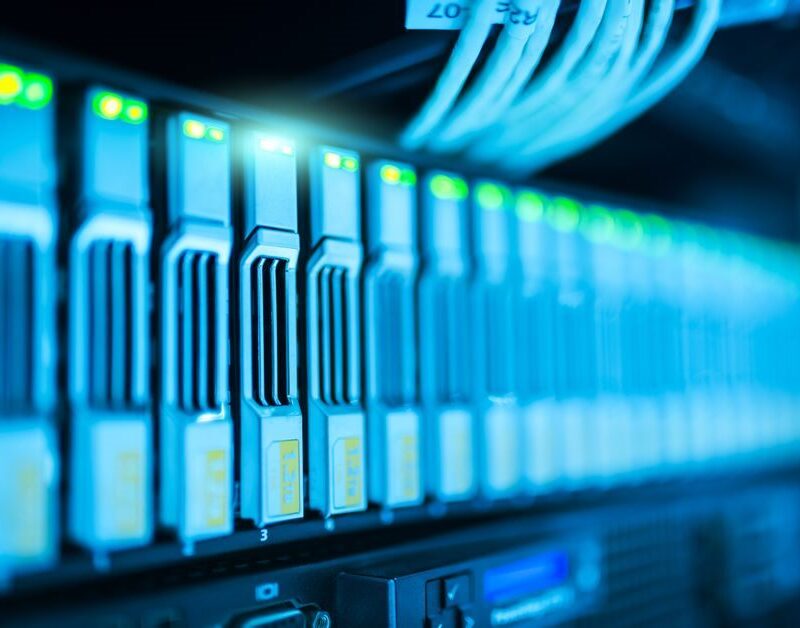 Row of server drive bays with status lights in a hosting data center rack