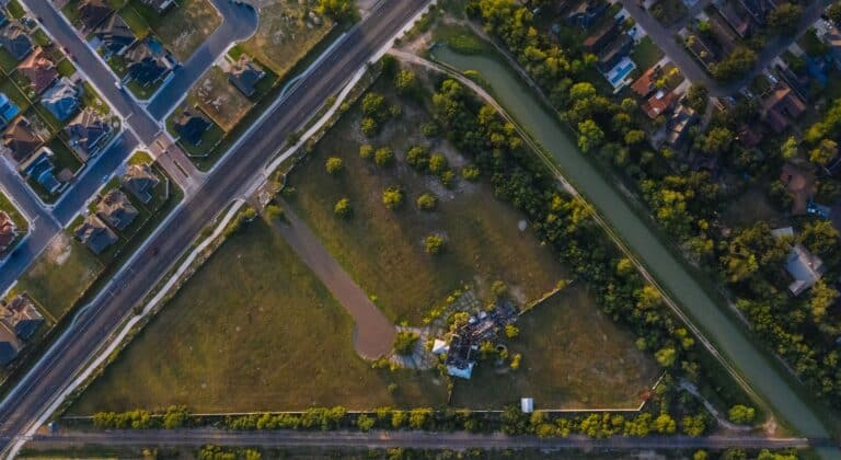 Aerial view of a Texas suburban neighborhood with streets, homes, and open land