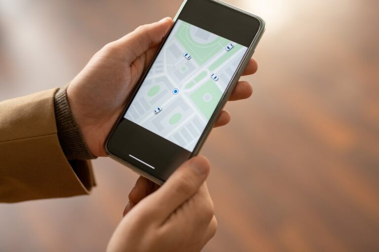 Two hands hold a smartphone showing a map app with location markers